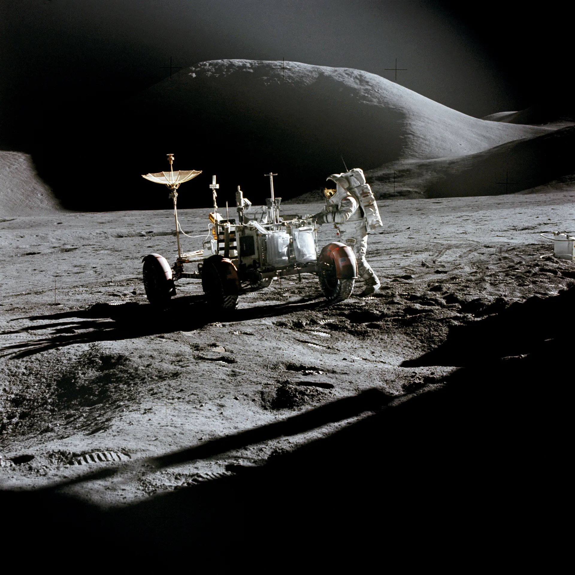 James Irwin works beside the Lunar Roving Vehicle, with Mount Hadley rising behind and the lunar module’s shadow in the foreground.