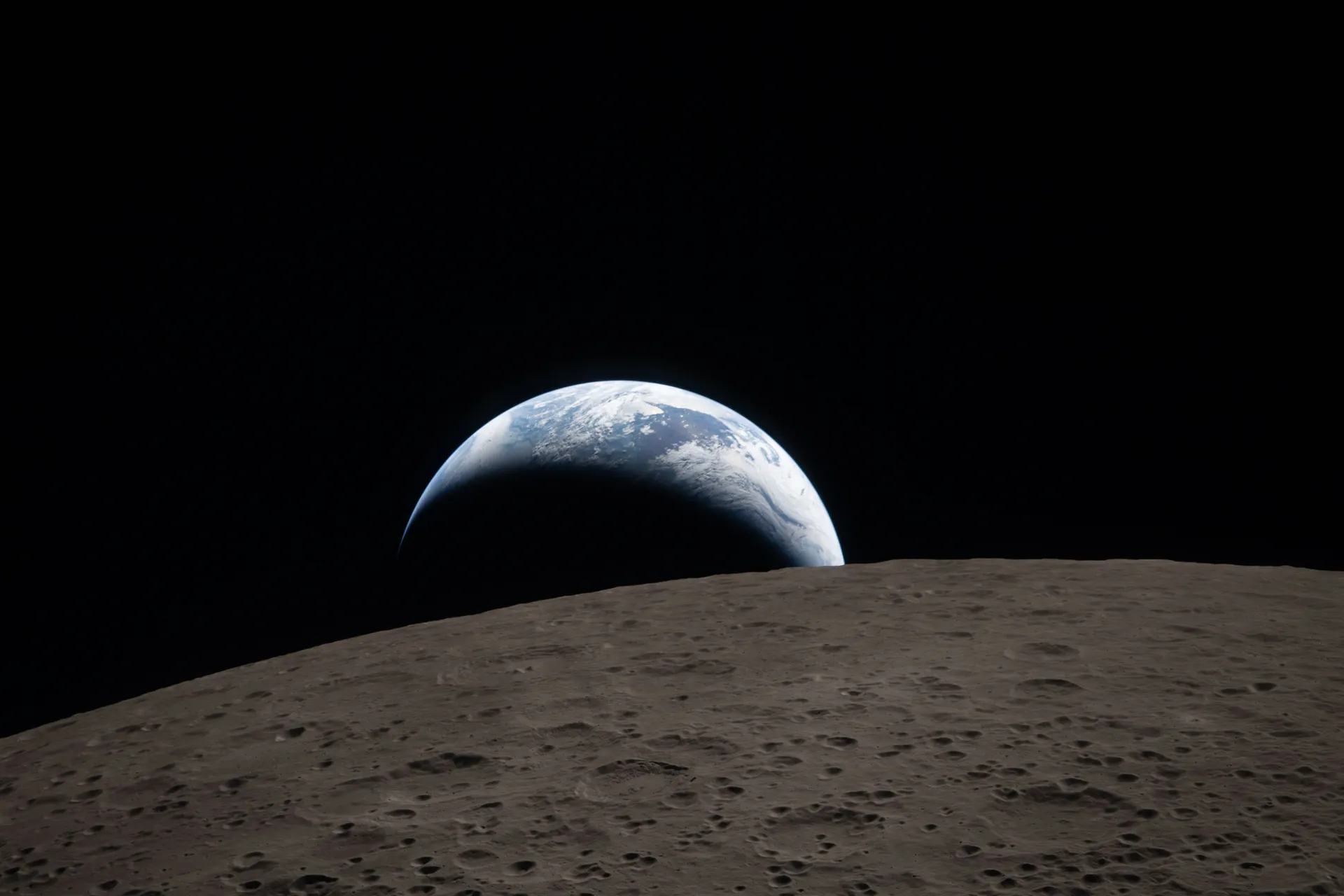A blue and white Earth, half in shadow, sets behind the gray, cratered horizon of the Moon.