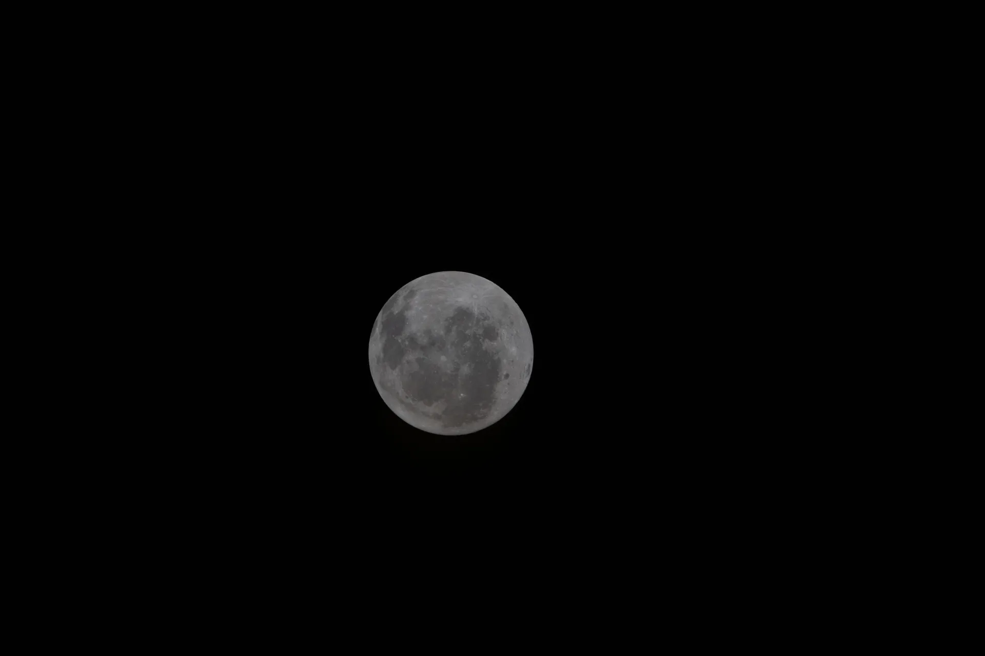 The Moon, photographed by the Artemis II crew with its South Pole at the top, shows a sunlit near side and part of the far side, with the dark rings of Orientale basin at the right edge.