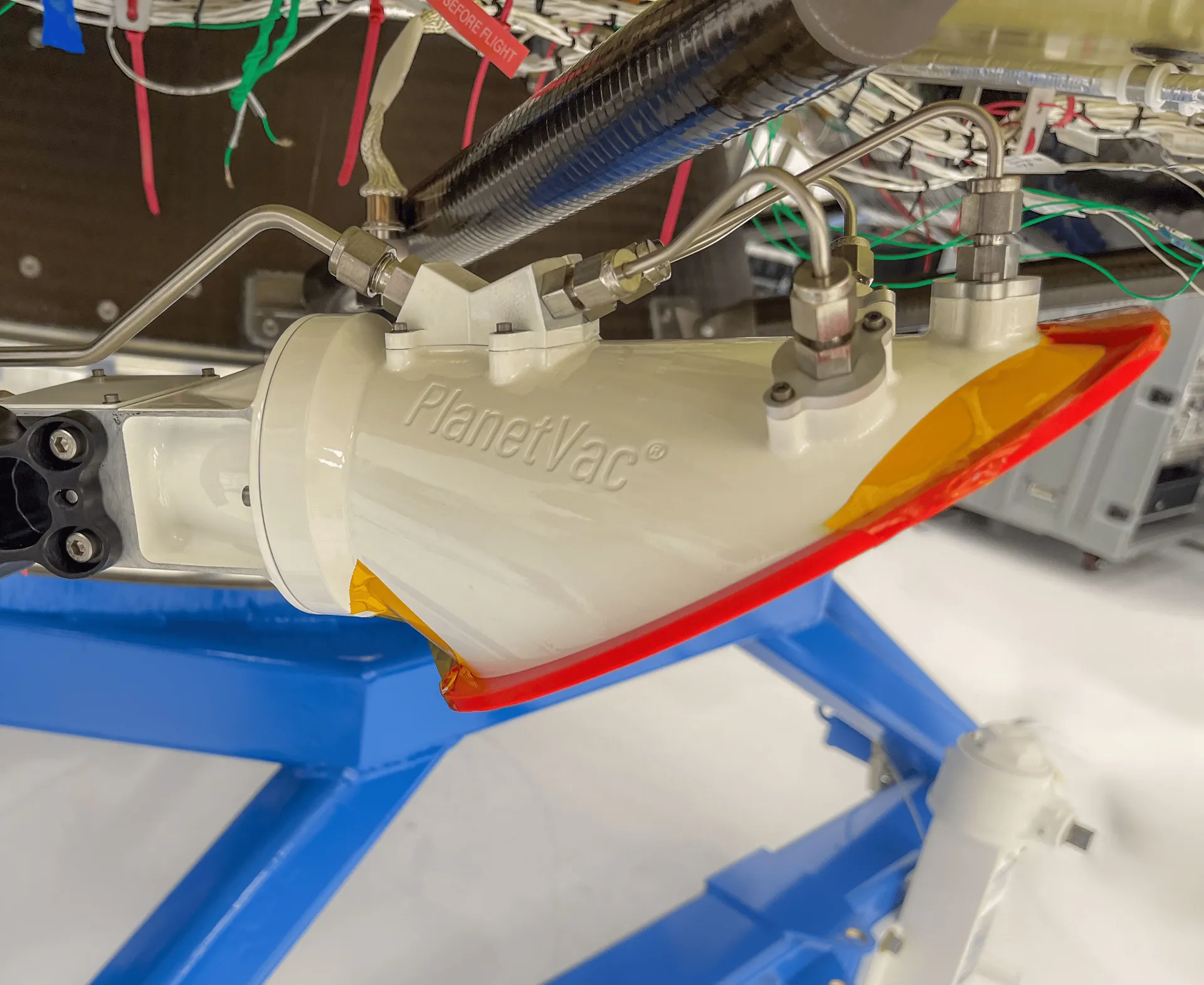 A white sampling device with tubes, mounted on the end of an arm on a lander, photographed before launch.