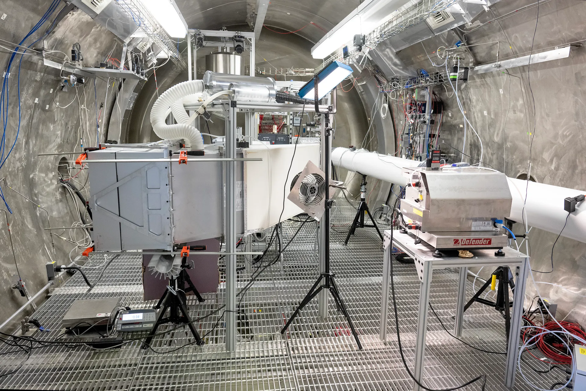 Filters and support hardware for Haven-1’s air-cleaning system stand on a grated floor inside a large steel test chamber.