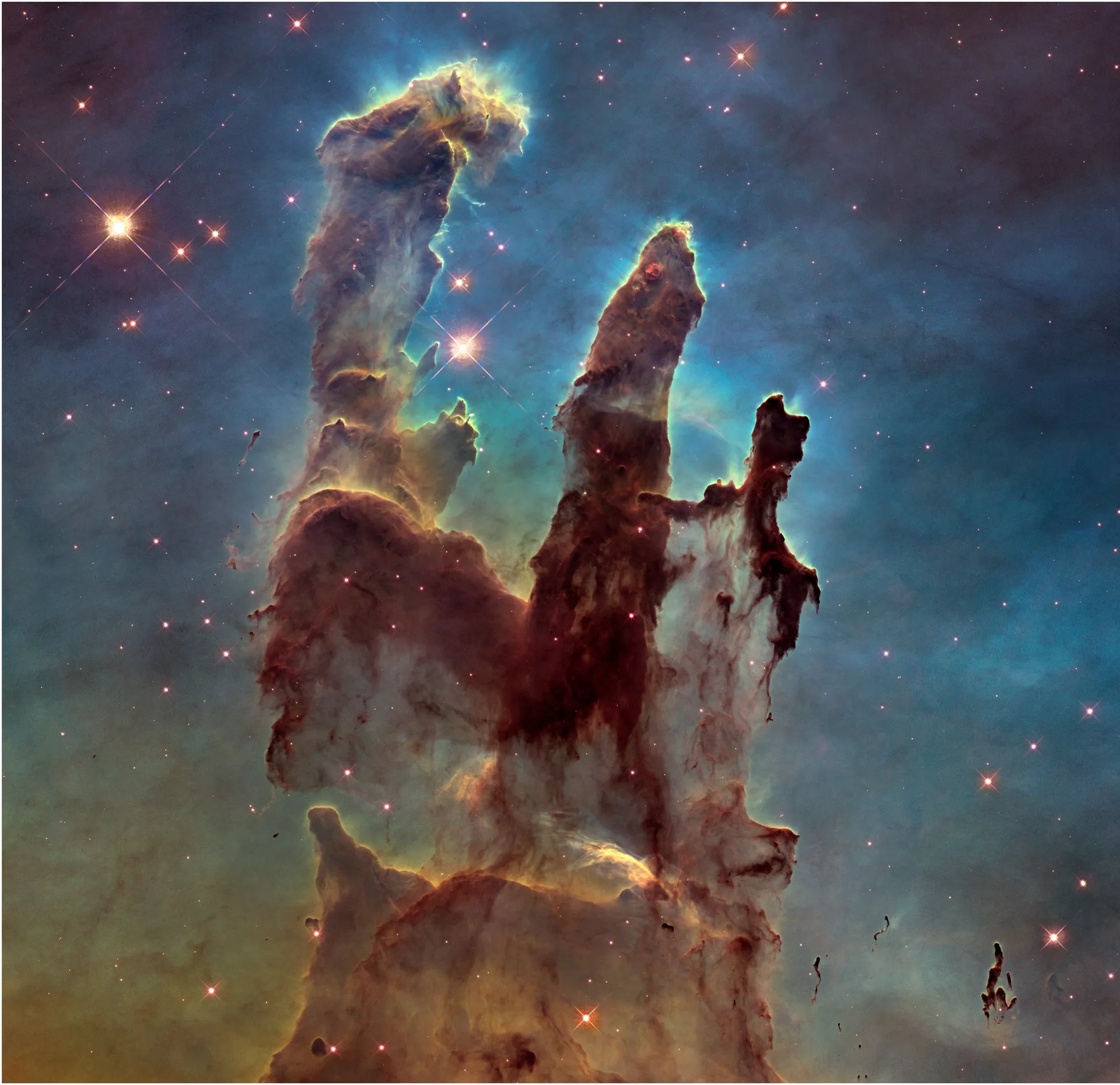 Tall columns of brown and rust-colored gas and dust rise against a blue-green haze, with only a few stars visible.