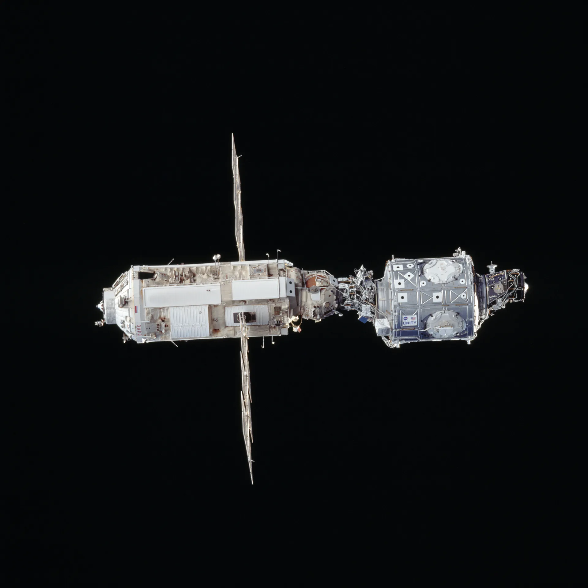 Two cylindrical modules joined end to end, one with long solar wings, against black space.