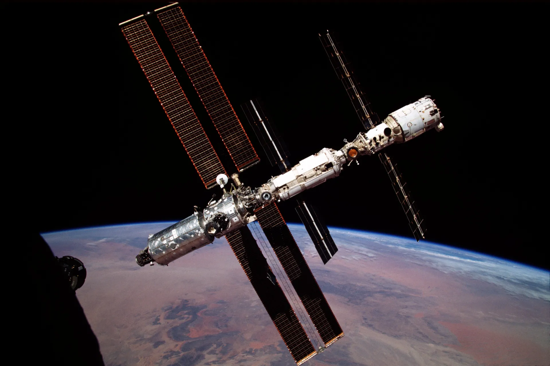 The young station with one large pair of solar arrays above Earth’s horizon.