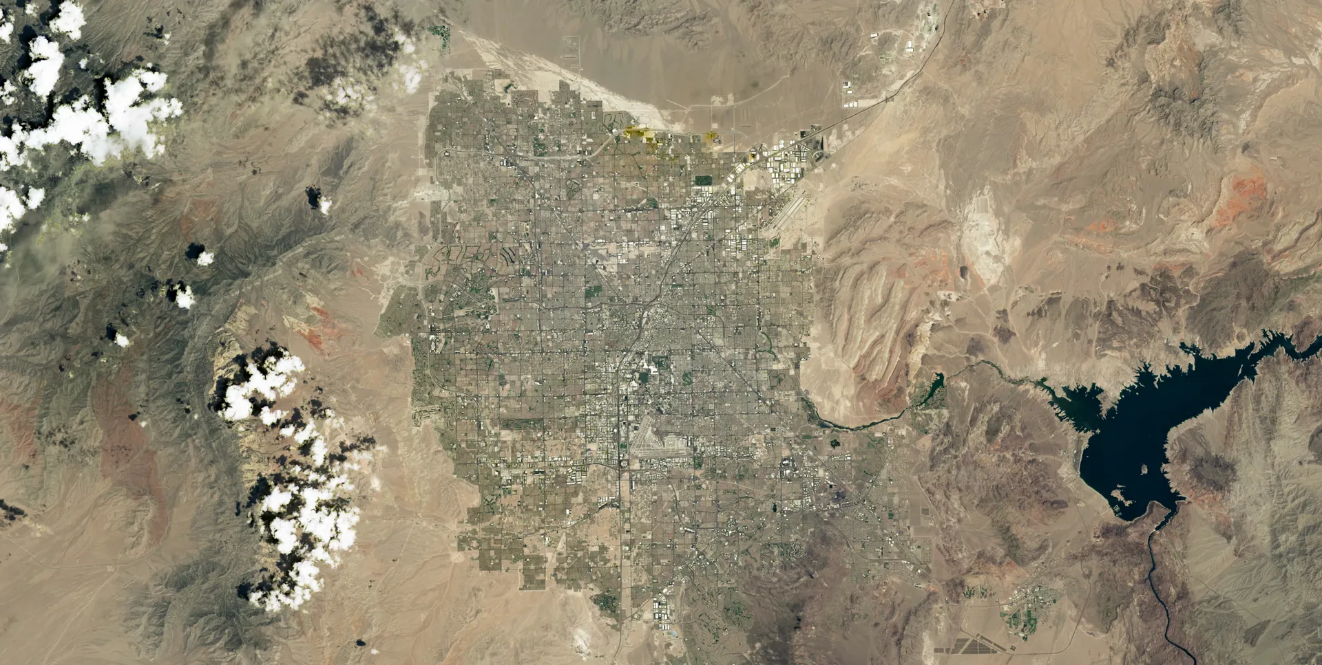 Las Vegas in 2025: the gray grid fills most of the valley floor, and Lake Mead at right is visibly smaller.